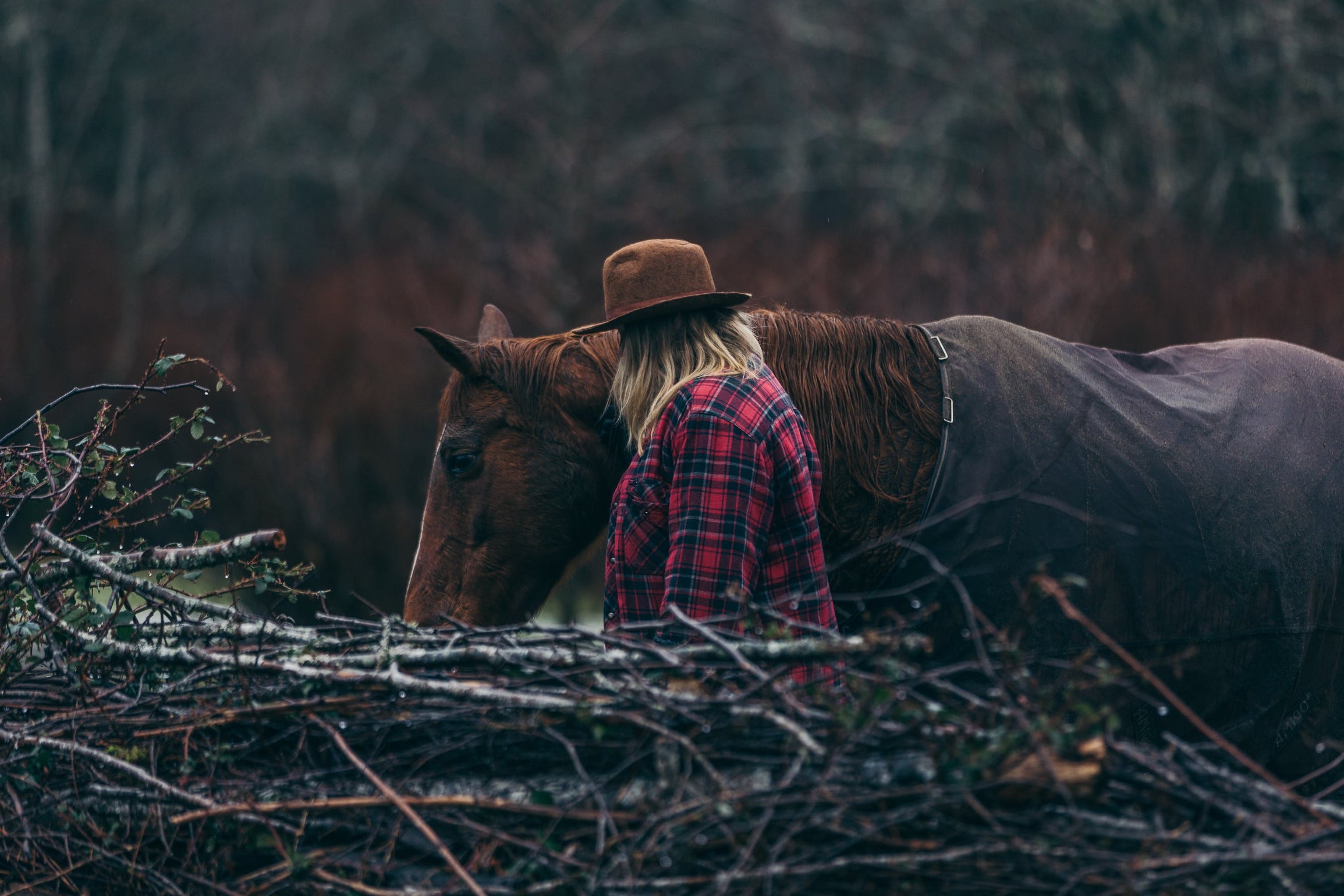 A woman walking next to her horse.